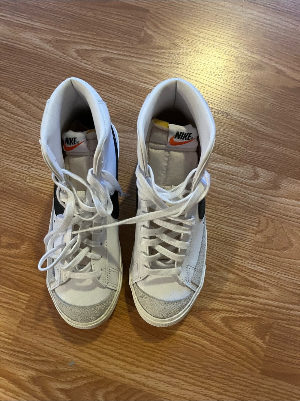 Nike White High-Top Sneakers with Black Swoosh and Orange Logo